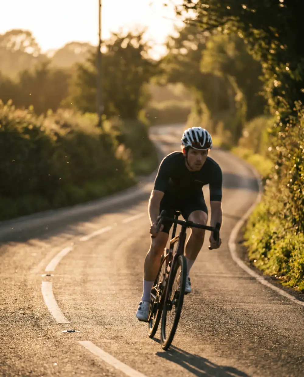 Ciclista entrenando en carretera al atardecer que sigue un plan de nutrición deportiva de resistencia en Madrid